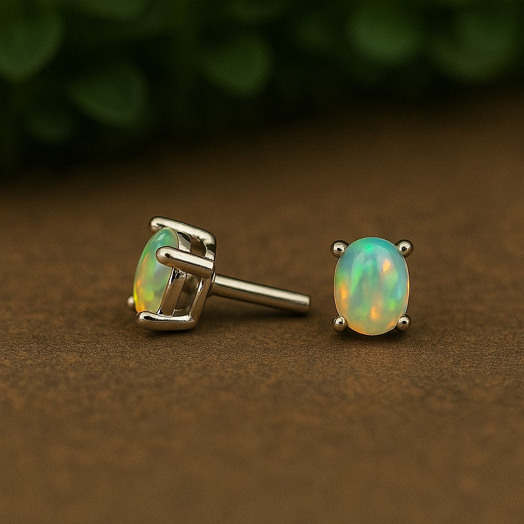 Natural opal stud earrings in 3x4mm size with sterling silver settings, featuring minimalist design and smooth cabochon stones.