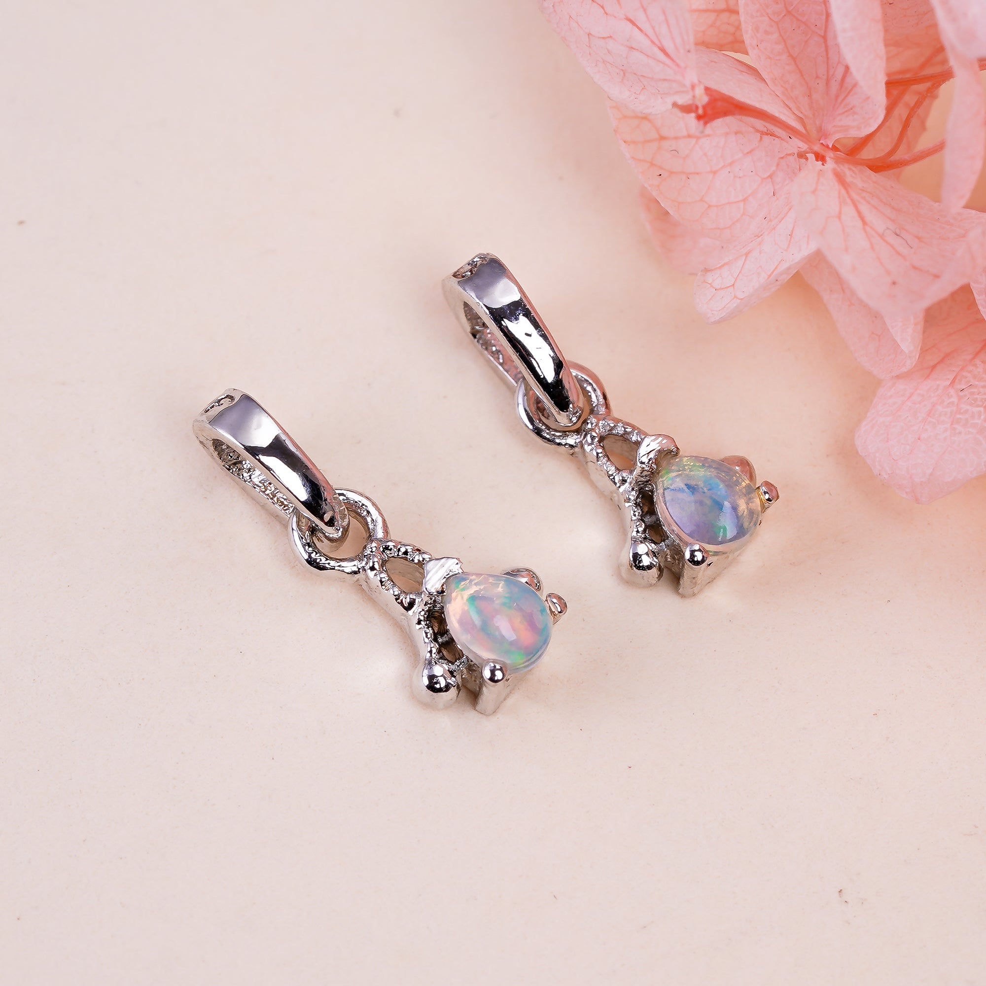 Natural opal pear pendant on a sterling silver chain, showcasing a tiny, shimmering opal stone in a delicate jewelry setting.